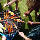 people grilling around a barbecue 