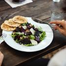 a person eating a salad at a restaurant 