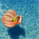 little girl on a pool toy in the water